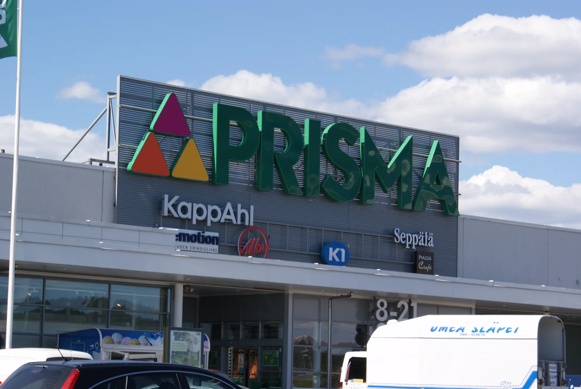 Prisma-myymälä, jonka julkisivuopasteiden taustalla on vaakasuuntainen säleikkö